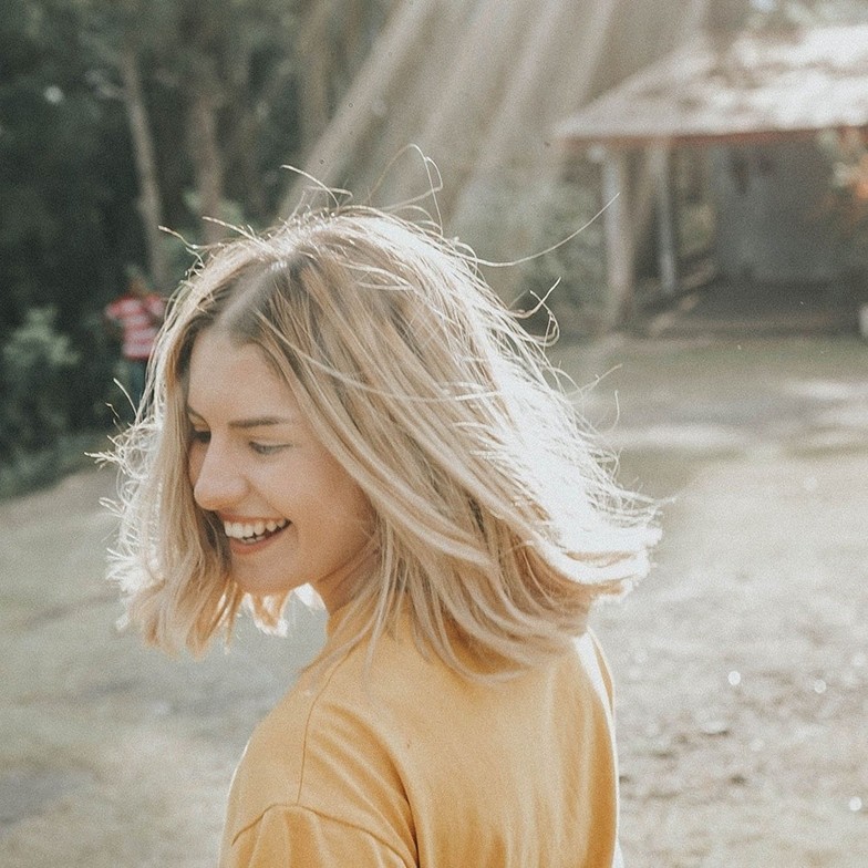 Woman sitting in sunlight symbolizing personal growth and self-expansion through therapy