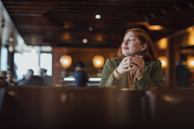 woman looking out a café window reflectively