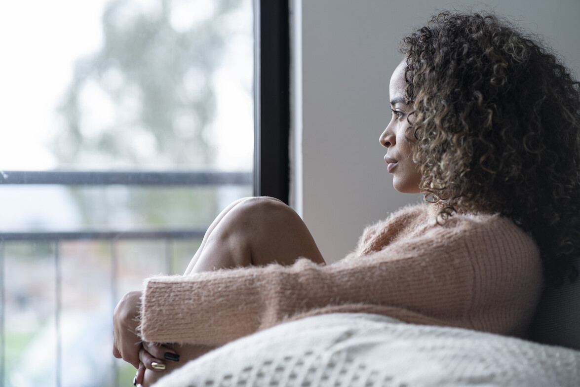Black woman sitting in the living room of her house