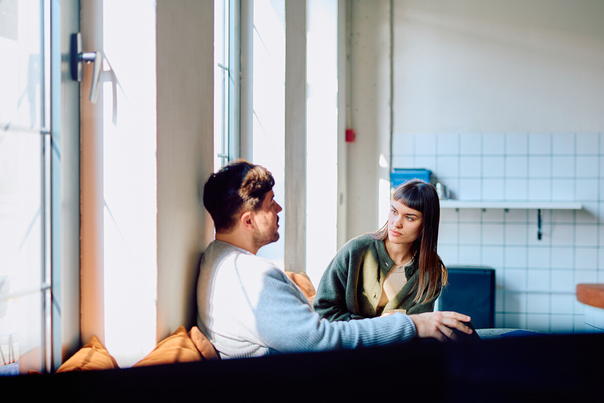 Young man and woman communicating during discussion at home